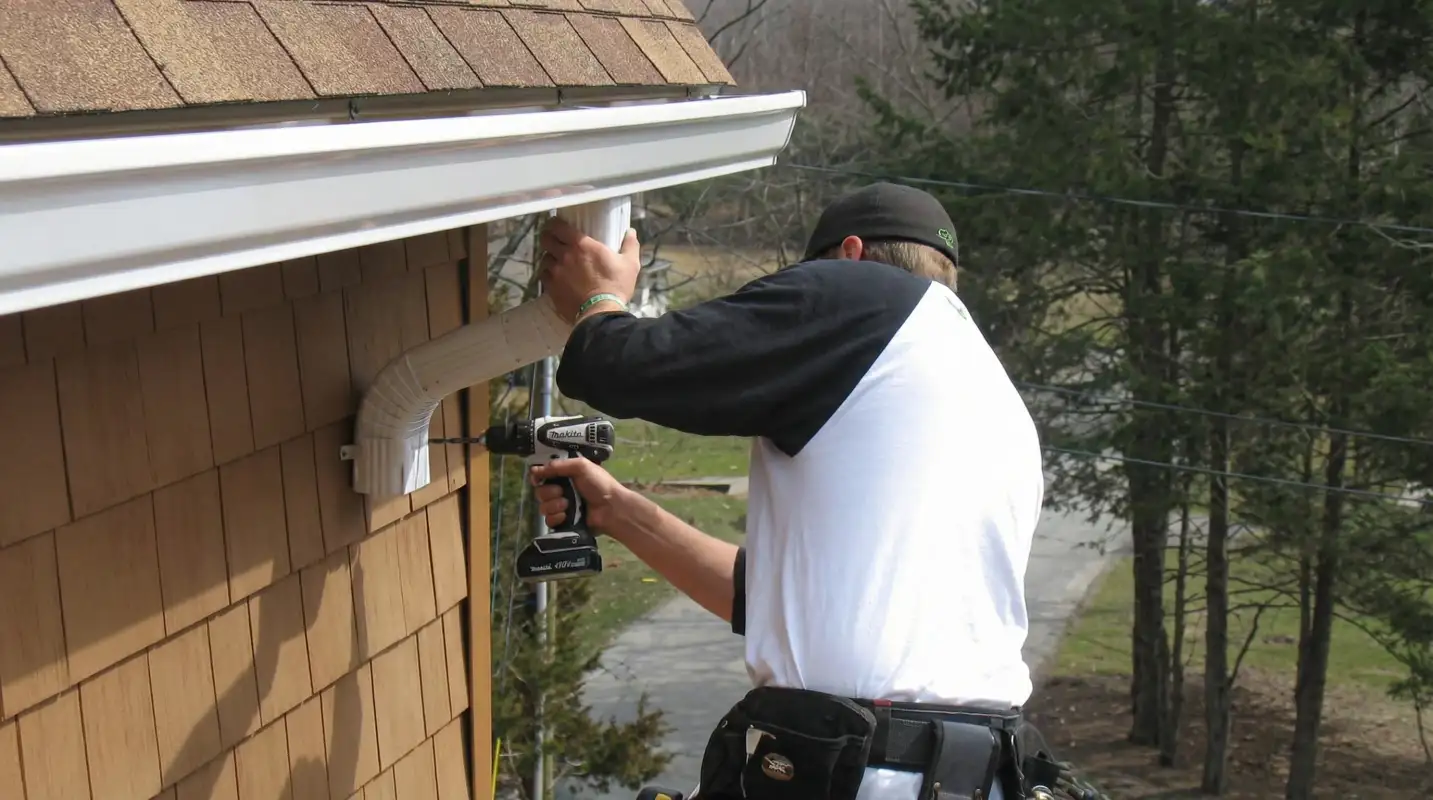 Professional contractor installing tan vinyl siding panels on a residential home exterior in Atlanta, GA